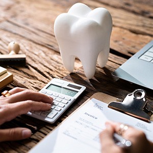 Patient calculating cost on desk with laptop