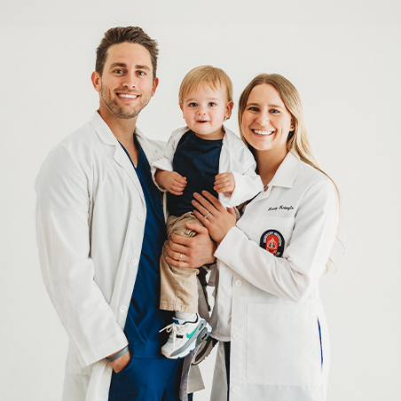 Doctors Kasey and Kyle Kringle holding their toddler