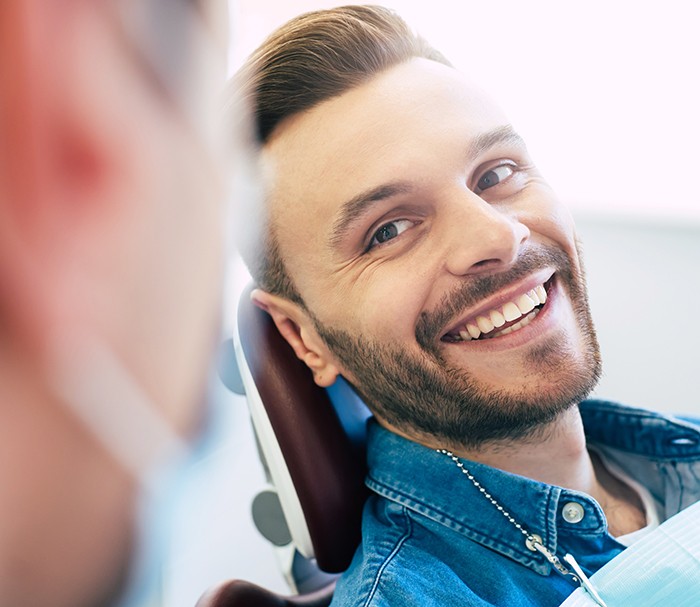 Man with beautiful smile looking at dentist