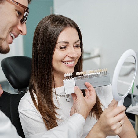 Dentist helping patient choose shade of veneers